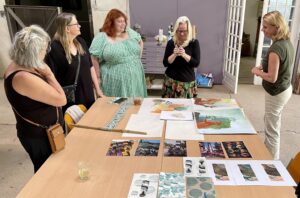 Learn how to paint during a creative holiday by participants reviewing each other’s work in an art workshop.